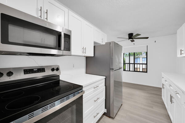 150 Pineview Road, Unit J6 Jupiter, FL 33469 - Photo 9 of 27 a kitchen with a stove microwave and refrigerator
