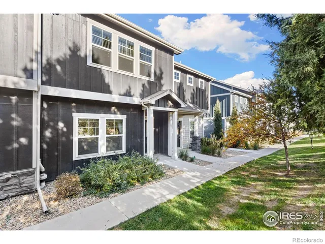 a view of a brick house with many windows next to a yard