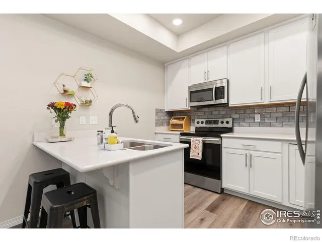 a kitchen with stainless steel appliances a sink a stove top oven a counter space and cabinets