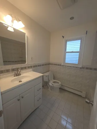 a bathroom with a toilet sink and mirror