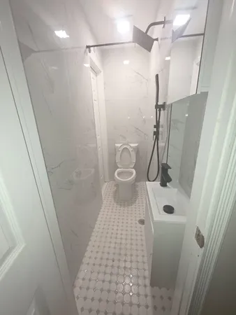 a bathroom with a sink a toilet a mirror and shower