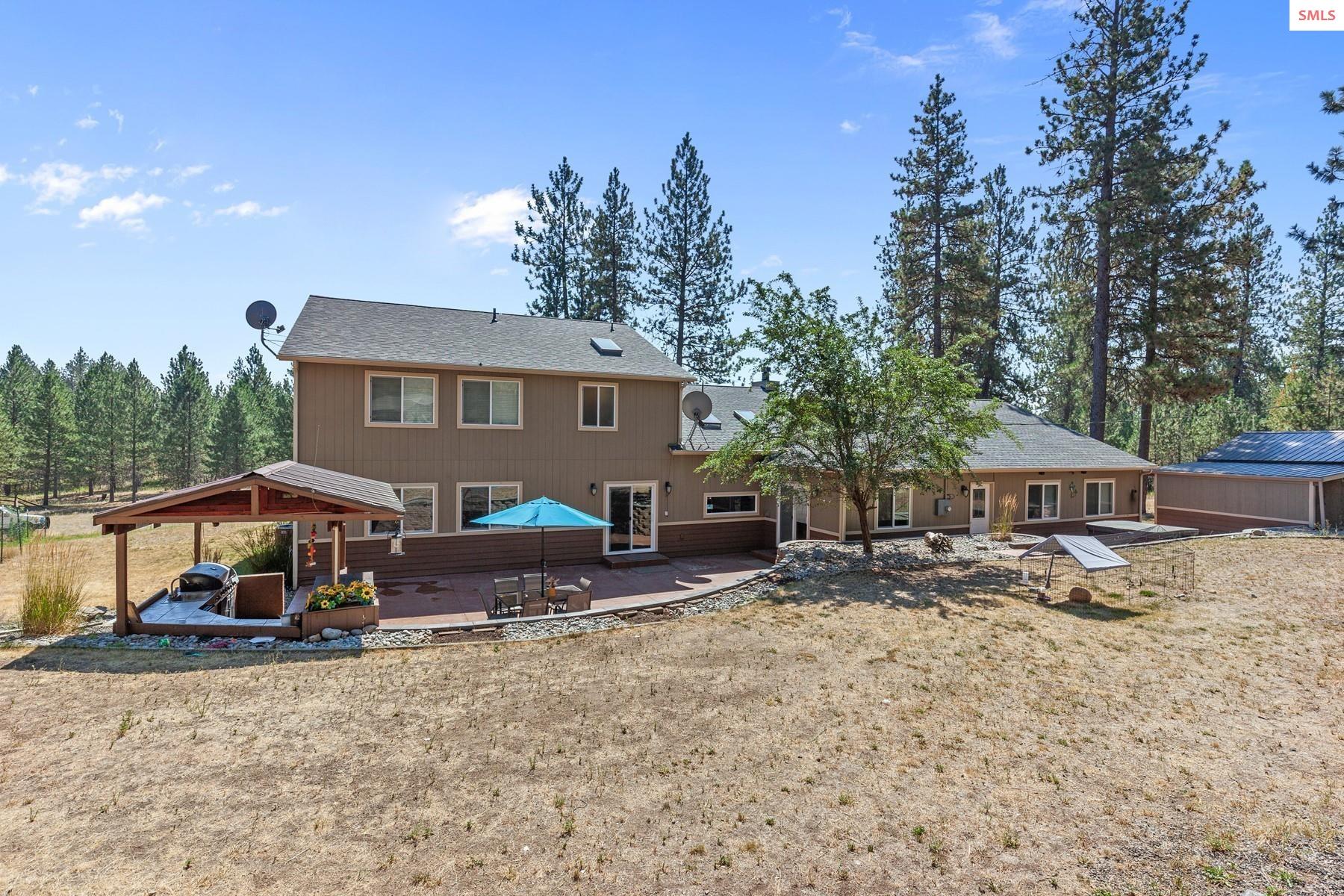 18341 West Highway 53 Rathdrum, ID 83858 - Photo 6 of 41 Back patio with hot tub, and outdoor kitchen offer easy indoor/outdoor living.