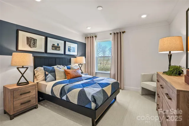 a bedroom with a bed and a lamp on dresser