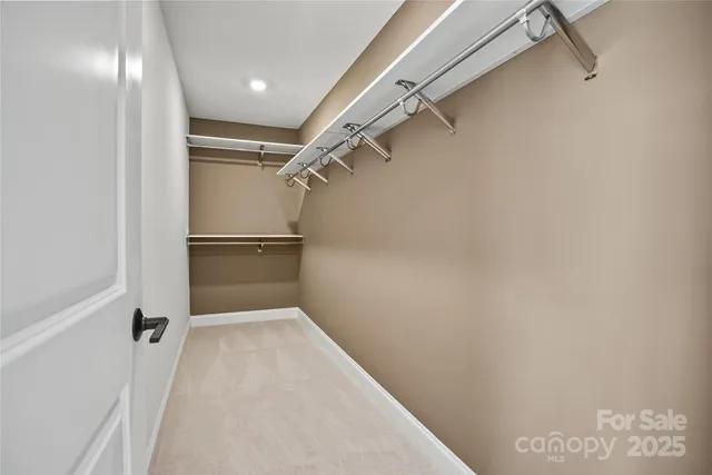 a view of walk in closet with empty racks