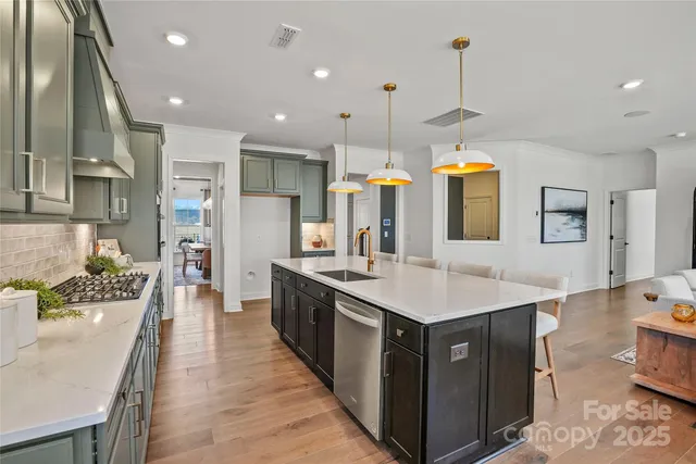 a large kitchen with stainless steel appliances kitchen island granite countertop a sink and a refrigerator