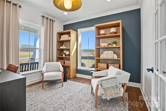 a living room with furniture and a floor to ceiling window