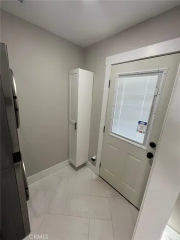an empty room with mirror and door