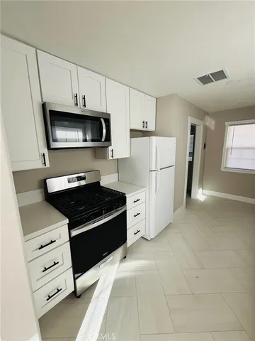 a kitchen with granite countertop a refrigerator and a stove