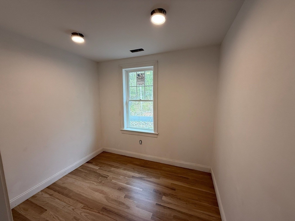 120 Maple Street Stow, MA 01775 - Photo 21 of 36 an empty room with wooden floor and windows