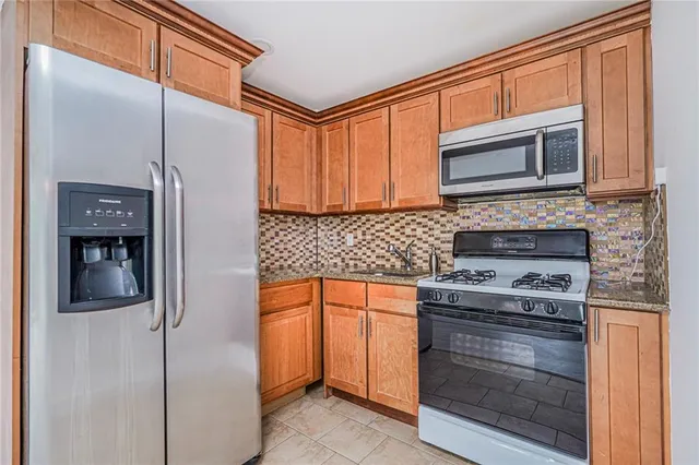 a kitchen with stainless steel appliances granite countertop cabinets and a stove top oven