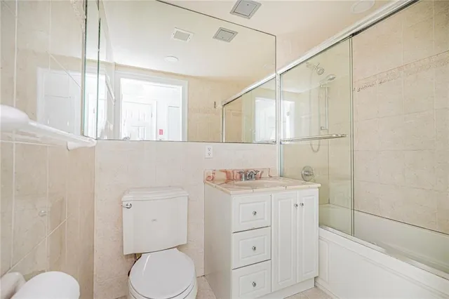 a bathroom with a granite countertop toilet sink and mirror