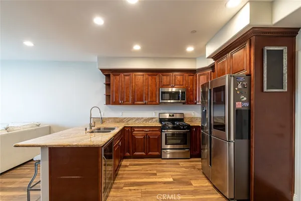 a kitchen with stainless steel appliances granite countertop a refrigerator a sink a stove and island