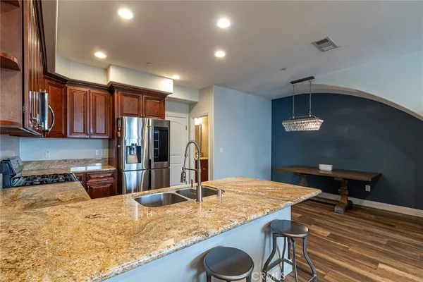 a kitchen with stainless steel appliances granite countertop a sink refrigerator stove and microwave