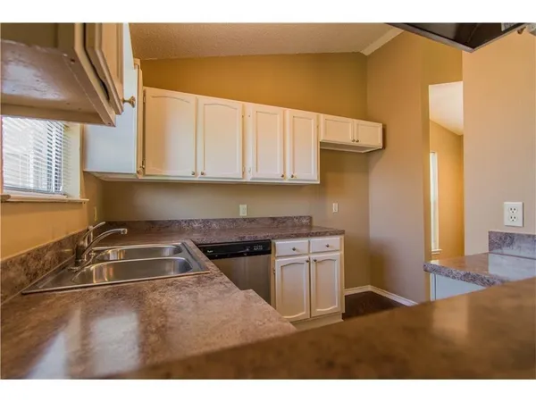 a kitchen with a sink cabinets and a stove