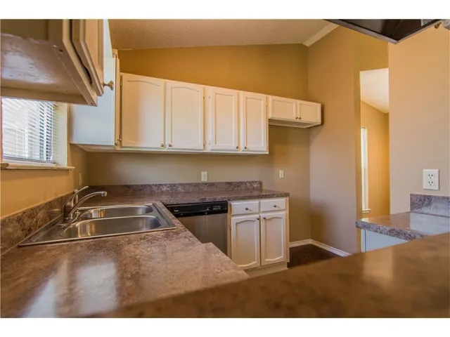 a kitchen with a sink cabinets and a stove