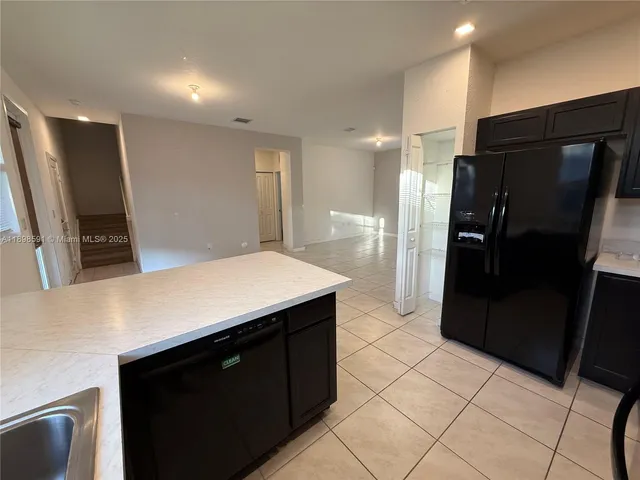 a kitchen with a refrigerator and a sink