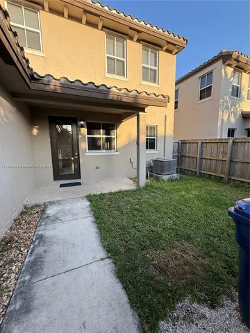 a view of a house with a small yard and a large window