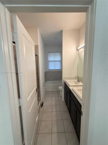 a kitchen with granite countertop a refrigerator and a stove top oven