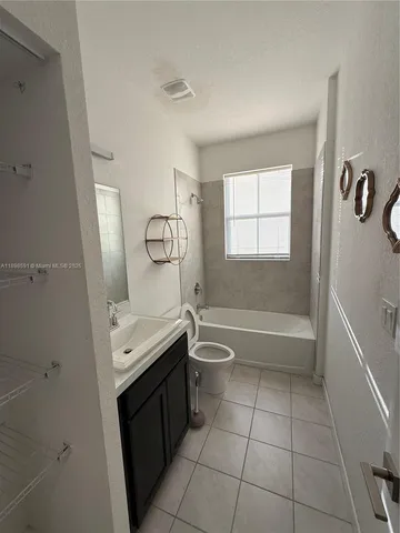 a bathroom with a granite countertop sink a toilet and bathtub