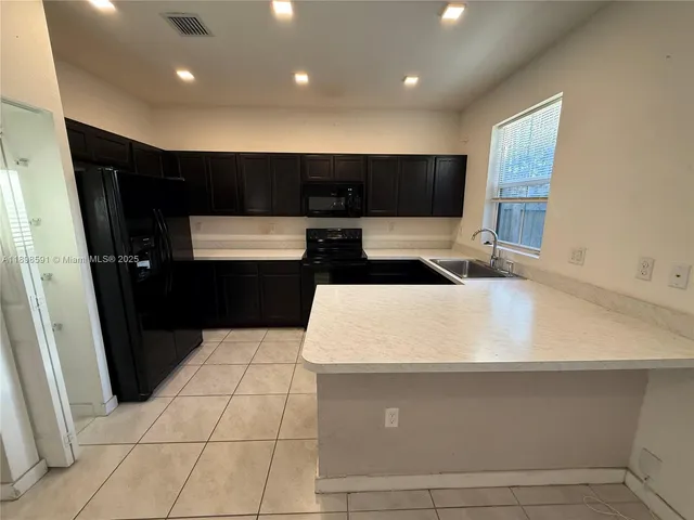 a large white kitchen with a sink and a stove top oven