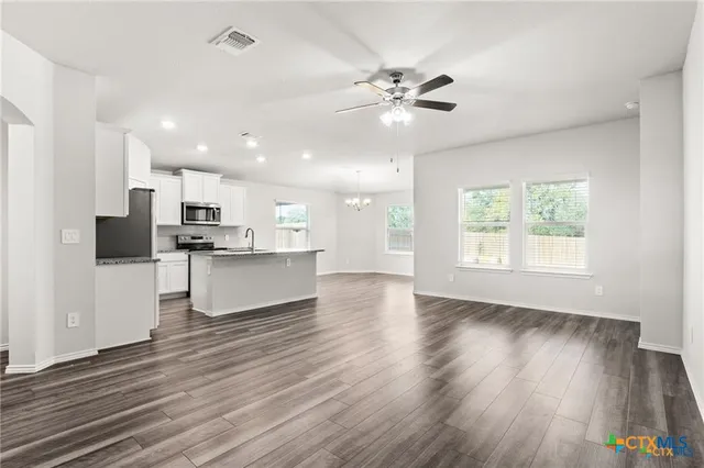 a view of kitchen with refrigerator microwave and wooden floor