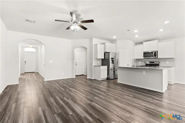 a view of kitchen with cabinets appliances and wooden floor