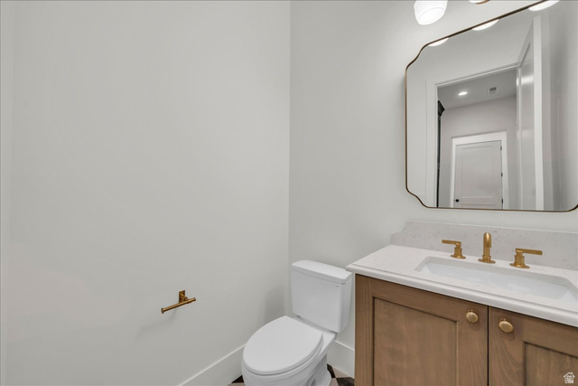 1620 Belayer Drive St. George, UT 84770 - Photo 19 of 51 Bathroom vanity featuring a light wood-finish cabinet with gold-toned hardware, an integrated sink with a light-toned countertop, and a matching gold-toned faucet