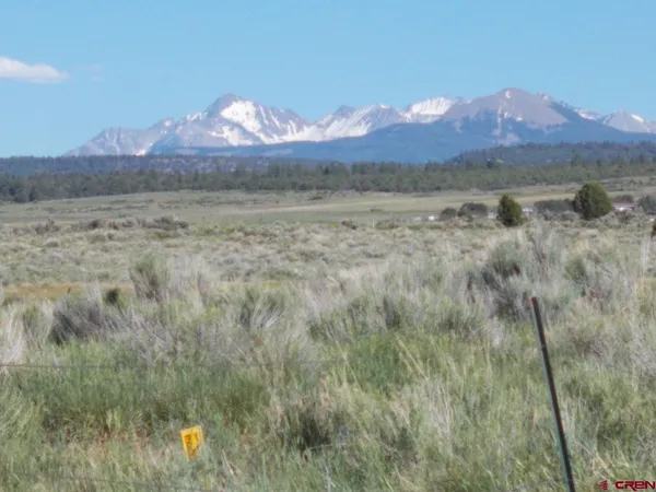 a view of mountain with sunset in background