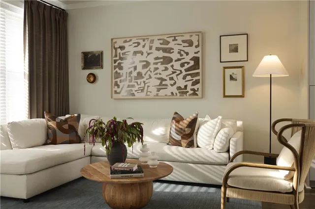 a living room with furniture and painting on the wall