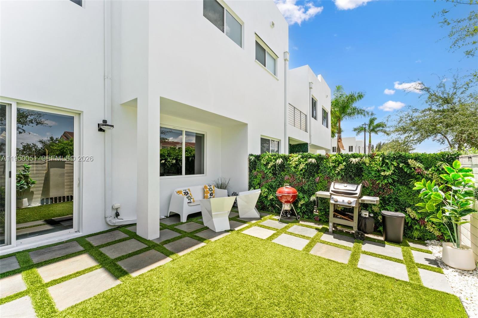 7226 Northwest 103rd Path Doral, FL 33178 - Photo 15 of 38 a view of a patio with table and chairs potted plants and large tree