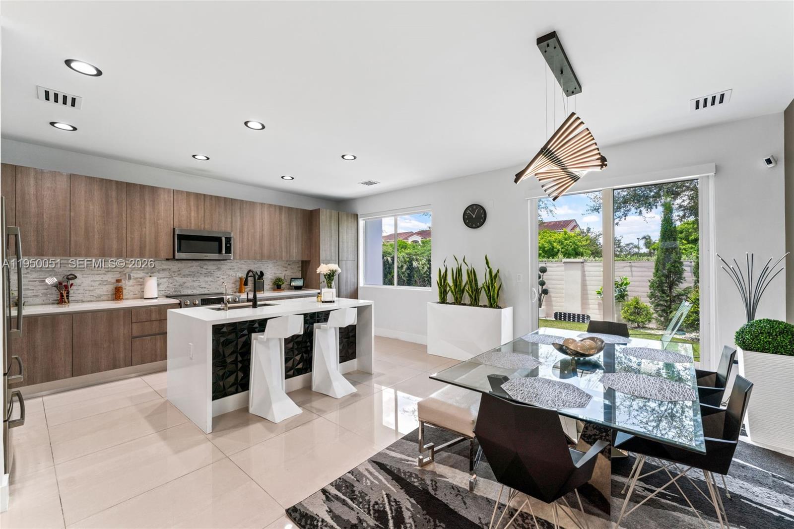 7226 Northwest 103rd Path Doral, FL 33178 - Photo 9 of 38 a kitchen with a sink a counter top space a large window and stainless steel appliances