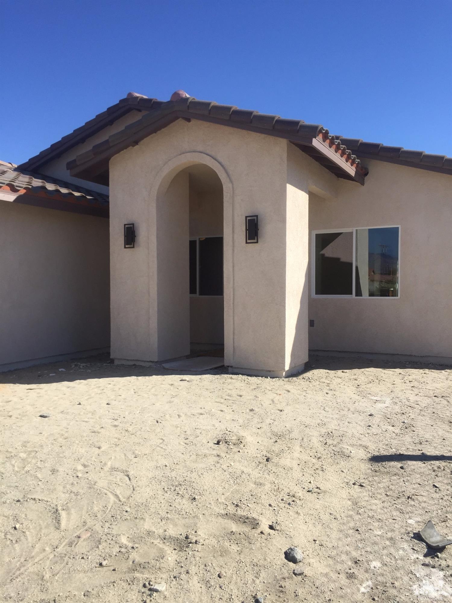 13689 Ocotillo Road Desert Hot Springs, CA 92240 - Photo 1 of 9 a front view of a house with a yard