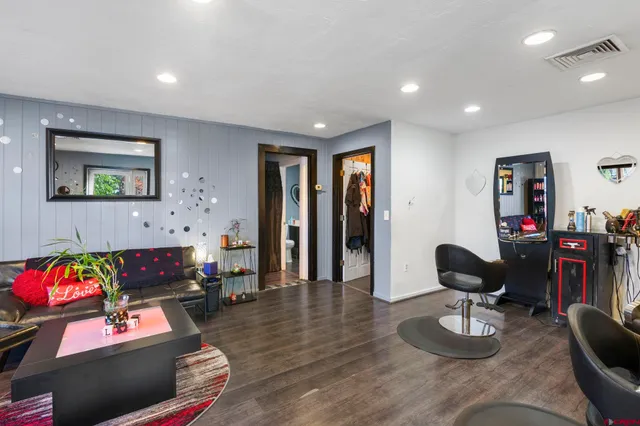 a living room with furniture chess board and a wooden floor