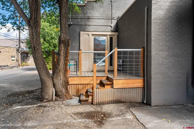 a view of a house with a tree and wooden fence