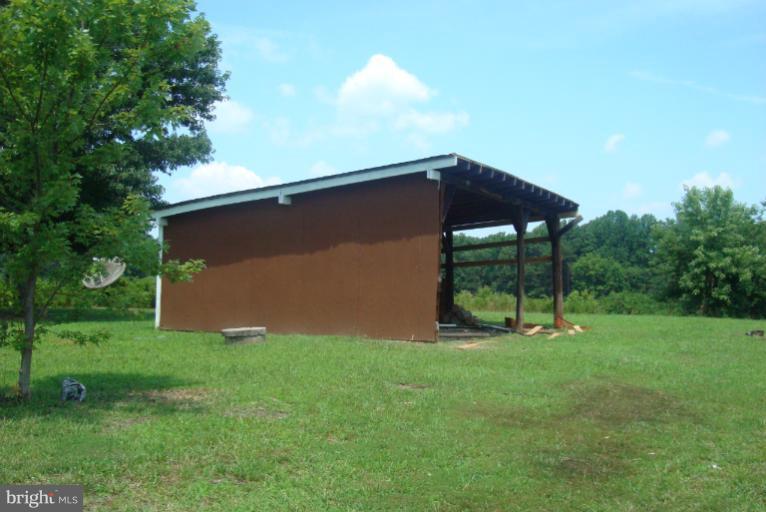 9001 Marye Road Partlow, VA 22534 - Photo 15 of 25 a backyard of a house with table and chairs under an umbrella