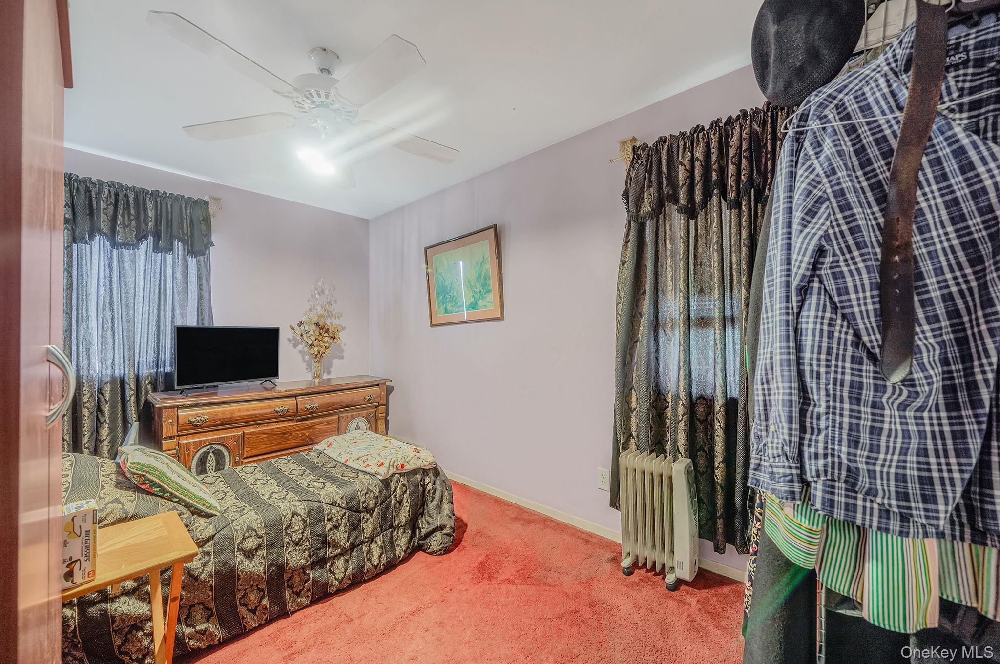 1169 Little E Neck Road West Babylon, NY 11704 - Photo 12 of 28 a bedroom with a bed and a flat screen tv