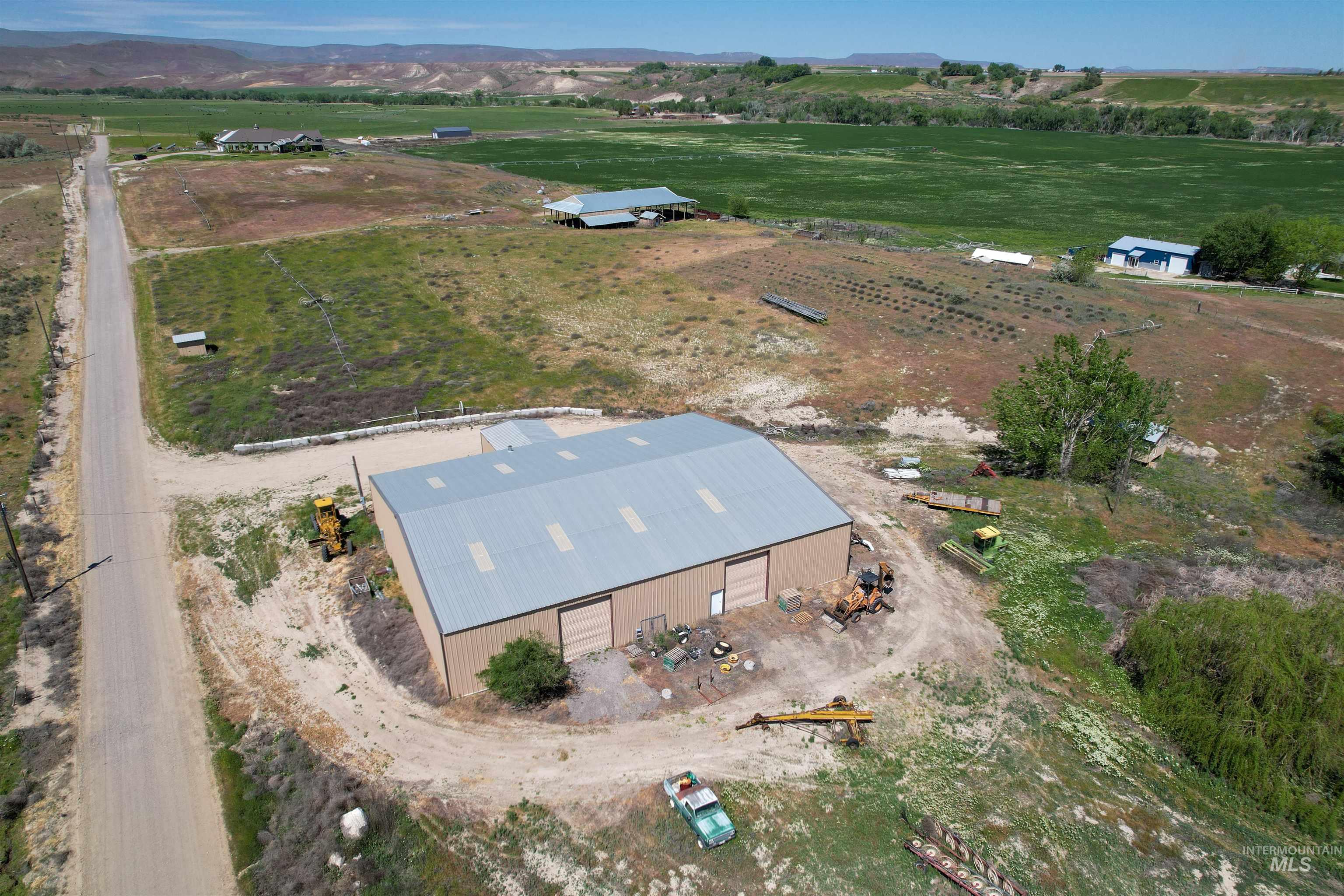1030 Desert Glen Road Adrian, OR 97901 - Photo 46 of 47 Industrial building featuring a metal roof, two roll-up doors, and a dirt access road