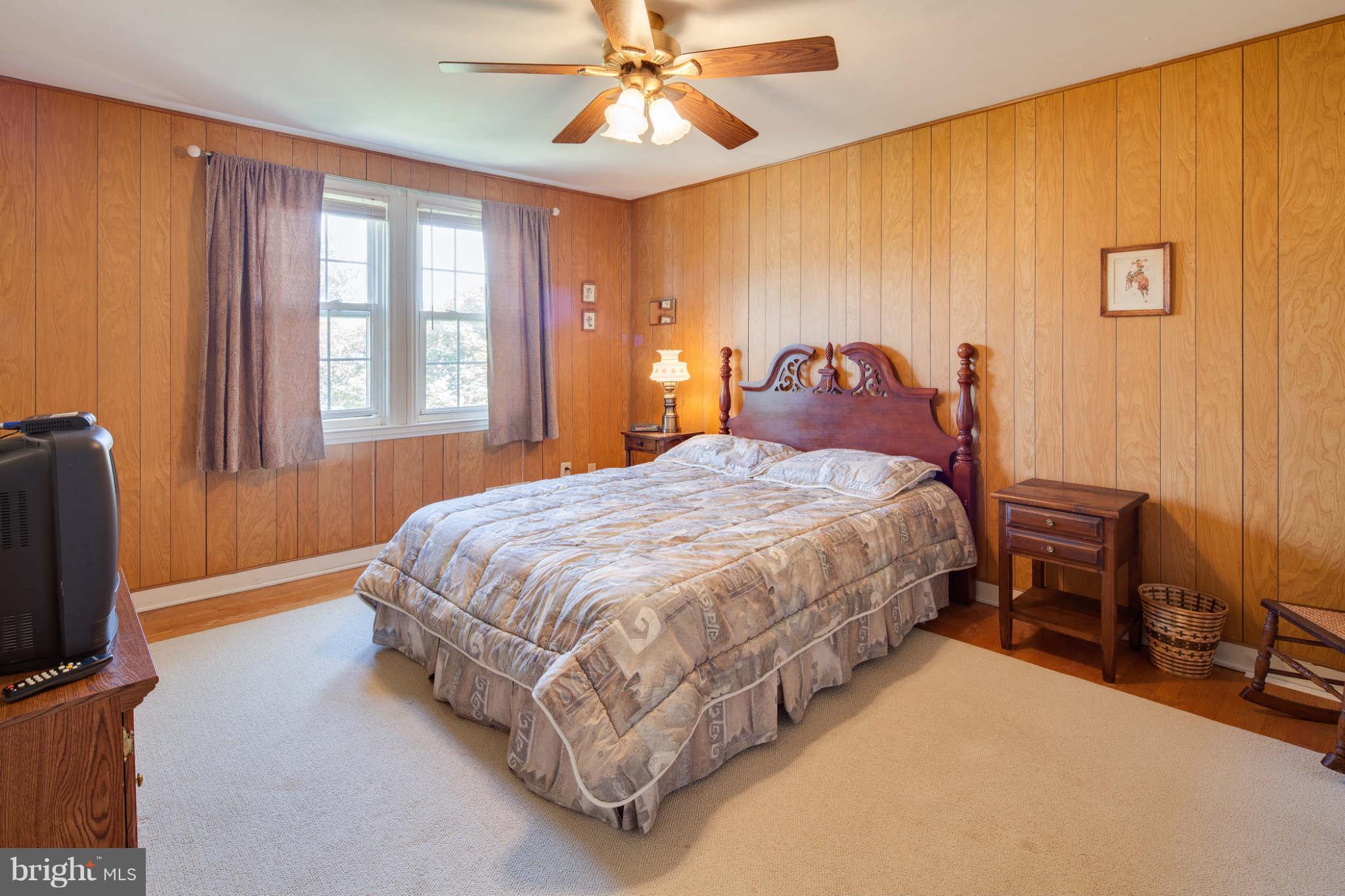 342 Greenlow Road Baltimore, MD 21228 - Photo 16 of 28 a spacious bedroom with a bed table chair and a chandelier
