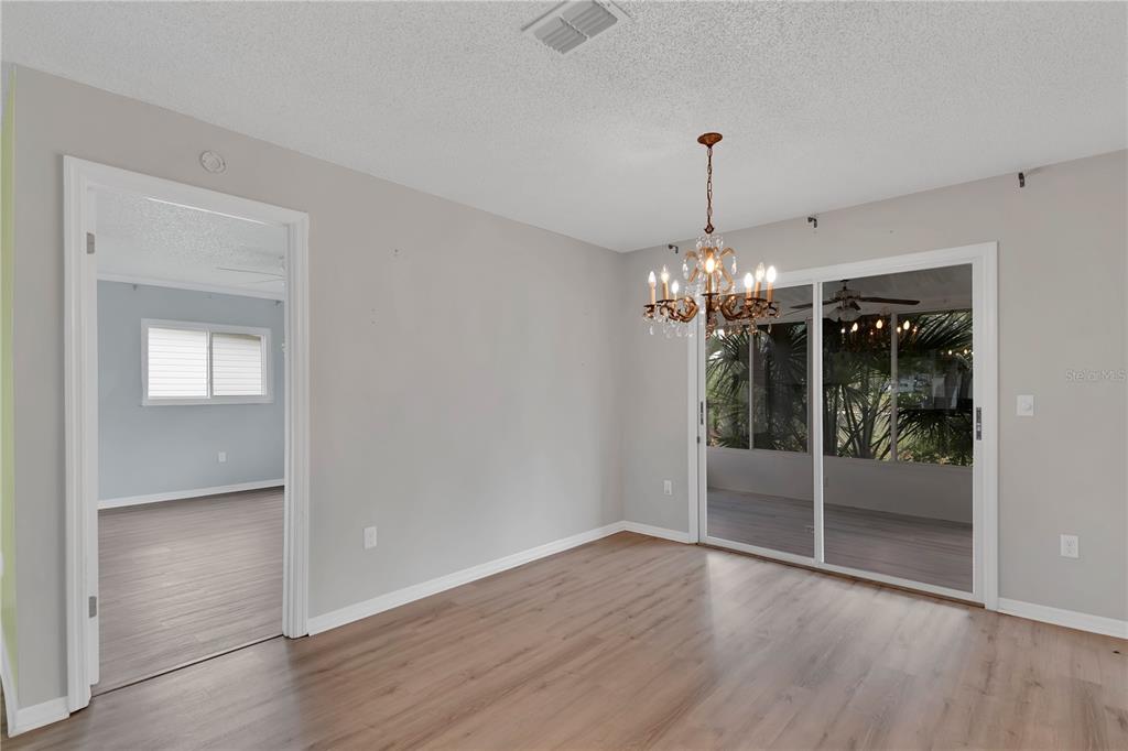 6366 Southwest 115th Street Road Ocala, FL 34476 - Photo 12 of 45 a view of a room with wooden floor chandelier and windows