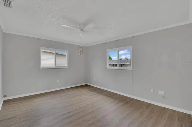 wooden floor in an empty room with a fan