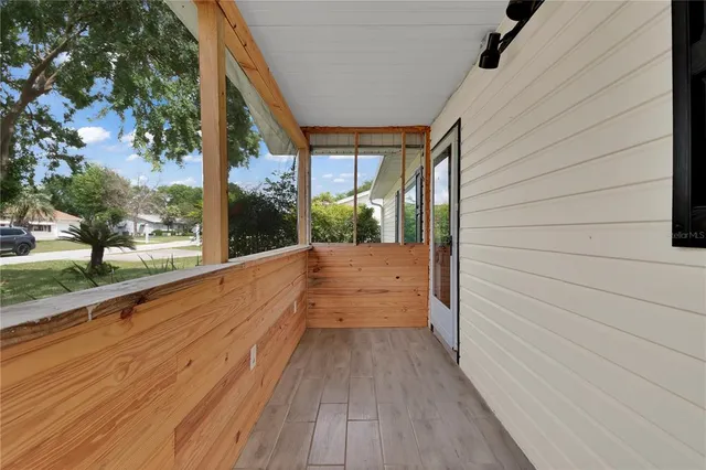 a view of a room with wooden floor and a ceiling fan