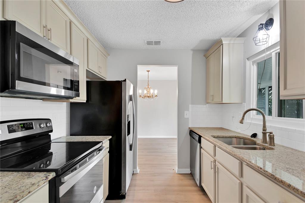 6366 Southwest 115th Street Road Ocala, FL 34476 - Photo 10 of 45 a kitchen with stainless steel appliances granite countertop a sink stove and refrigerator