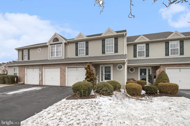 a view of a white house with a large tree in front of it