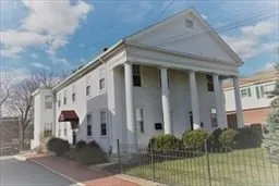 a front view of a house with a yard and potted plants