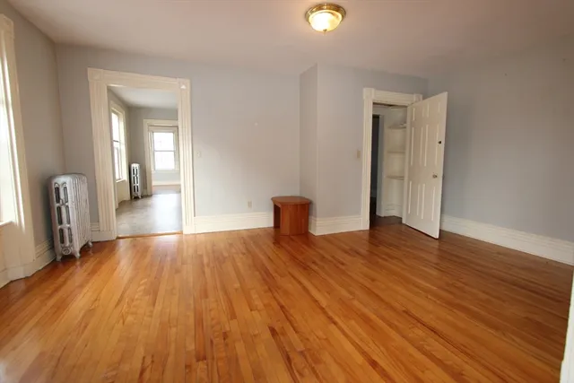 a view of a livingroom with wooden floor and a window