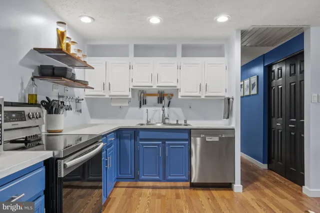a kitchen with kitchen island granite countertop a sink stainless steel appliances and cabinets