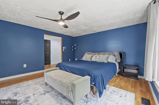 a spacious bedroom with a bed and a flat screen tv