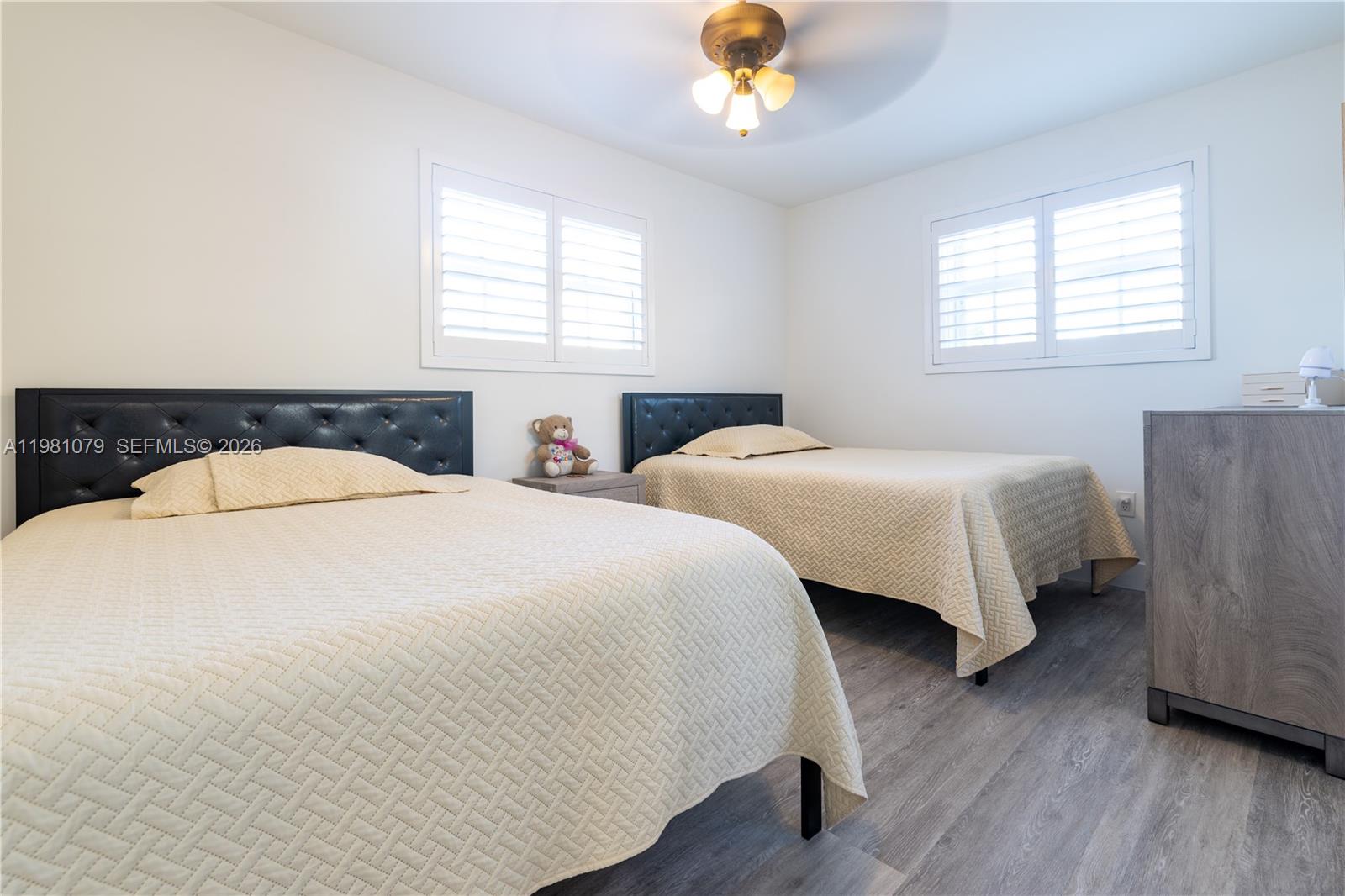 19600 Gulfstream Road Cutler Bay, FL 33157 - Photo 13 of 36 a bedroom with two beds and a chandelier