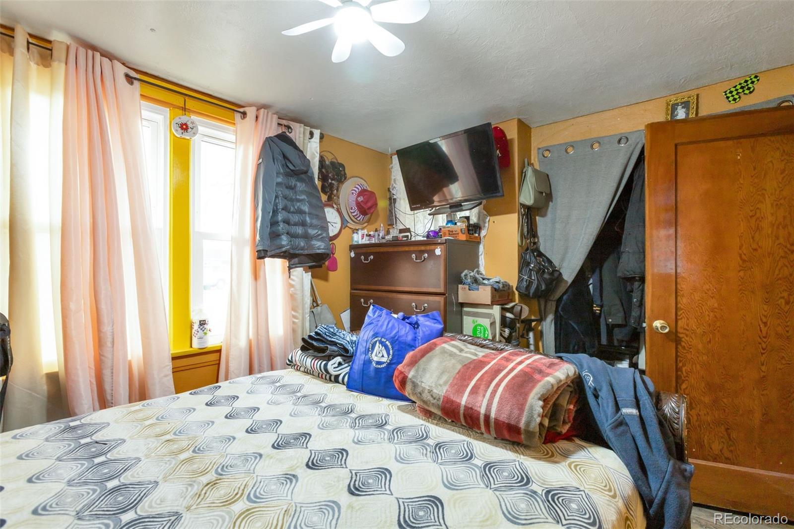 6830 Olive Street Commerce City, CO 80022 - Photo 13 of 25 a bedroom with a bed and a window
