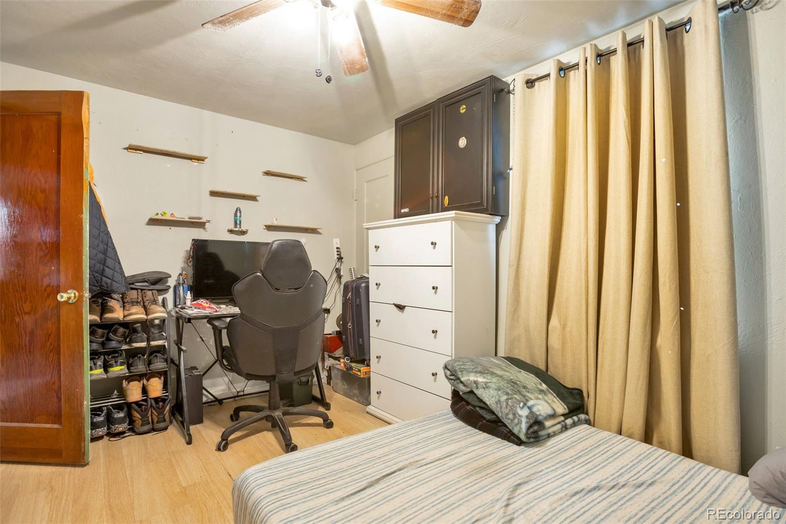 6830 Olive Street Commerce City, CO 80022 - Photo 14 of 25 a bed room with a bed and a chair